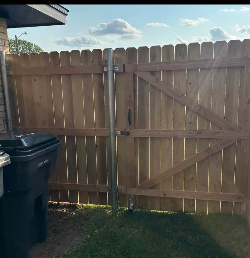 Old fence panels torn out, posts and bare dirt exposed